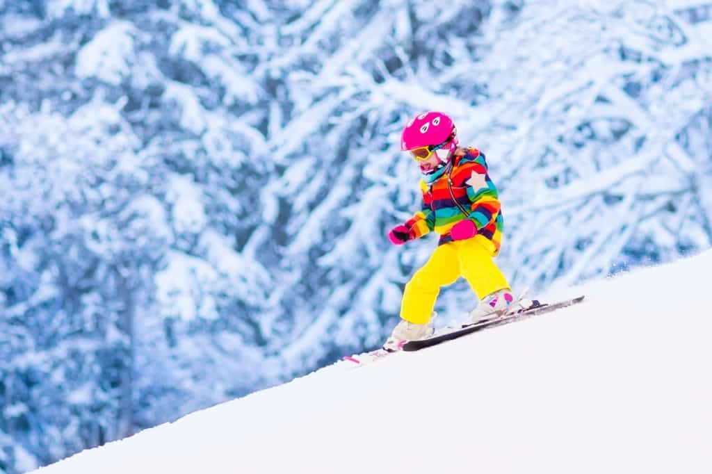 Kind skiet van een berg af