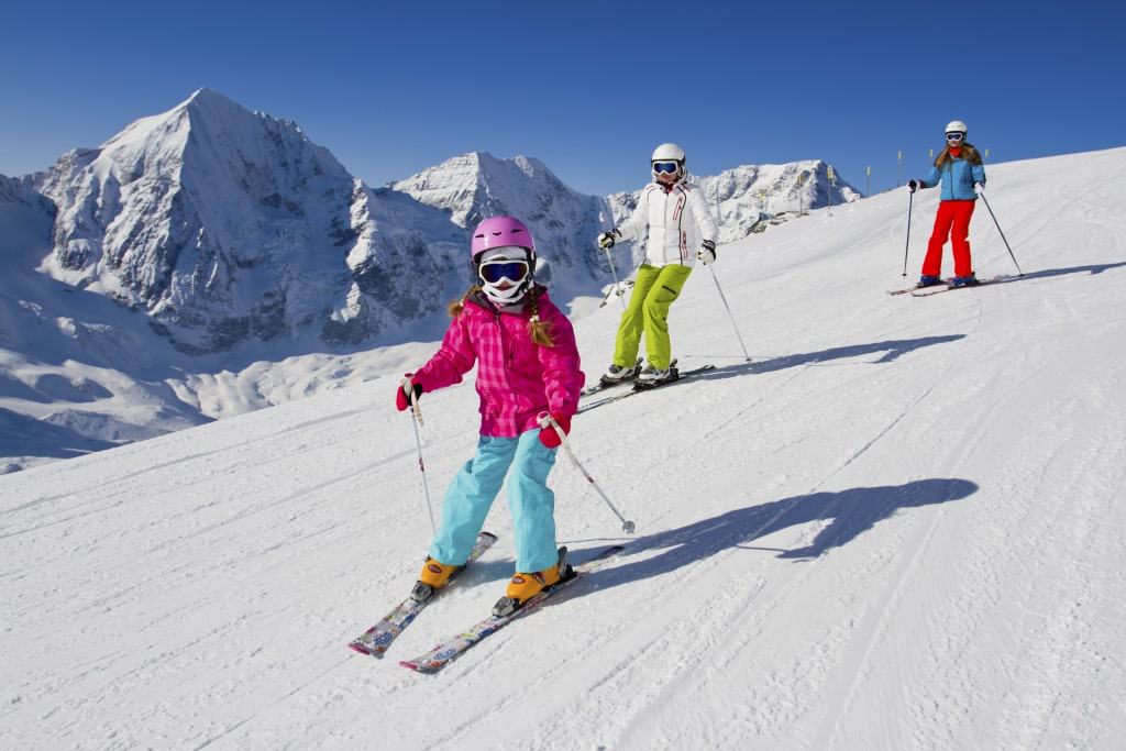 Familie aan het skiën van een skipiste