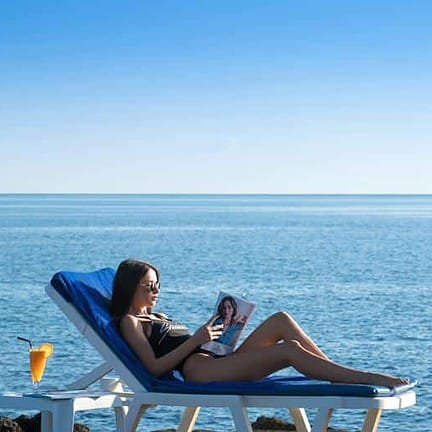 Vrouw ligt op het strand van Silva Beach Resort in Chersonissos, Kreta