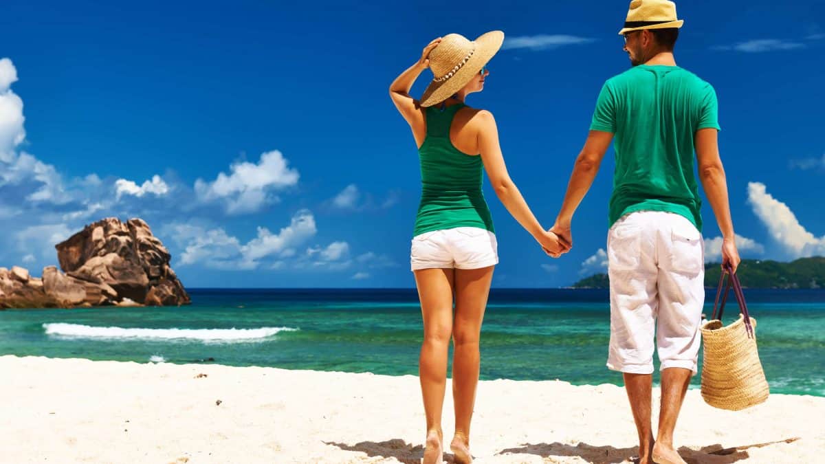 Vrouw en man hand in hand op het strand