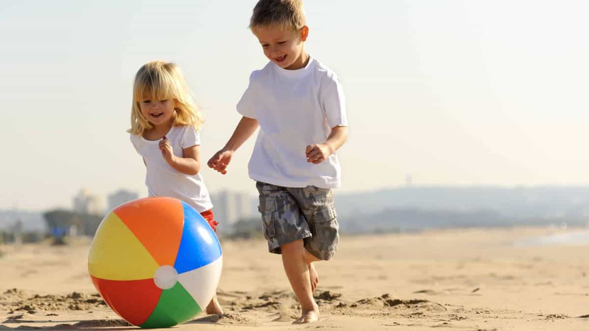 twee kinderen spelen met een strandbal op het strand