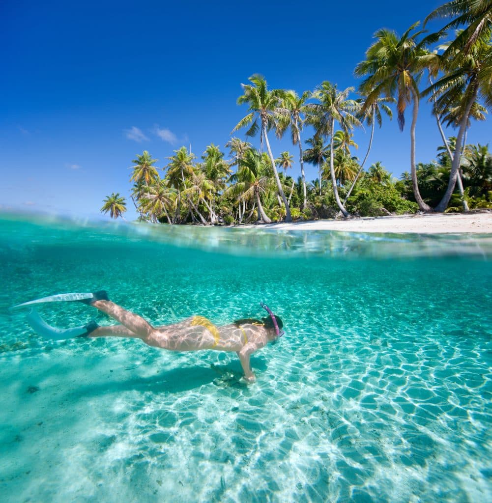 Vrouw aan het snorkelen onder water bij een tropisch eiland