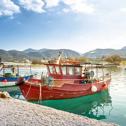 Traditionele vissersboten en schelpen in de haven van Milatos, Kreta, Griekenland