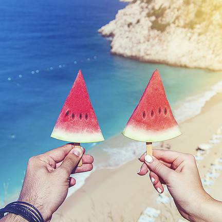 twee watermeloenen stokje strand zee uitzicht