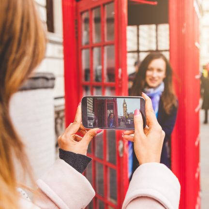 Vriendinnen maken een foto bij een telefooncel in Londen, Engeland