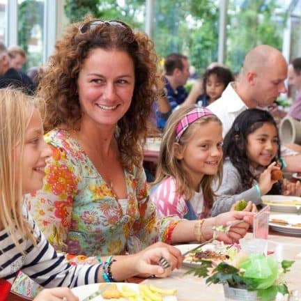 Familie aan het eten in het restaurant van Hotel en attractiepark Wunderland Kalkar in Kalkar, Duitsland