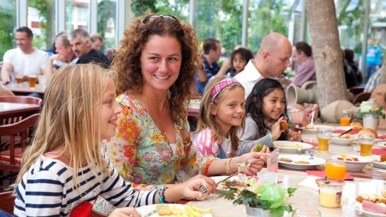 Familie aan het eten in het restaurant van Hotel en attractiepark Wunderland Kalkar in Kalkar, Duitsland