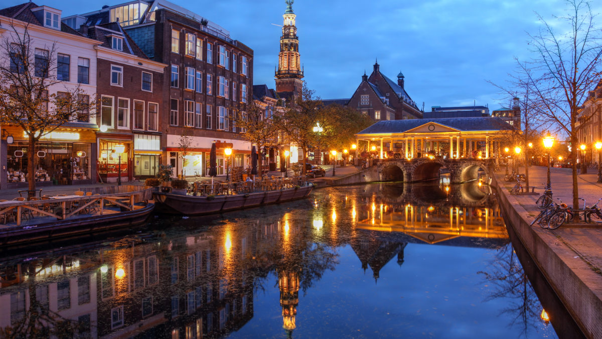 Gracht en verlichte brug in Leiden, Zuid-Holland