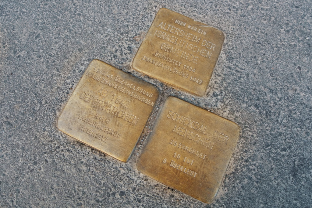 Drie struikelblokken (Stolpersteine) op een stoep in Berlijn, Duitsland