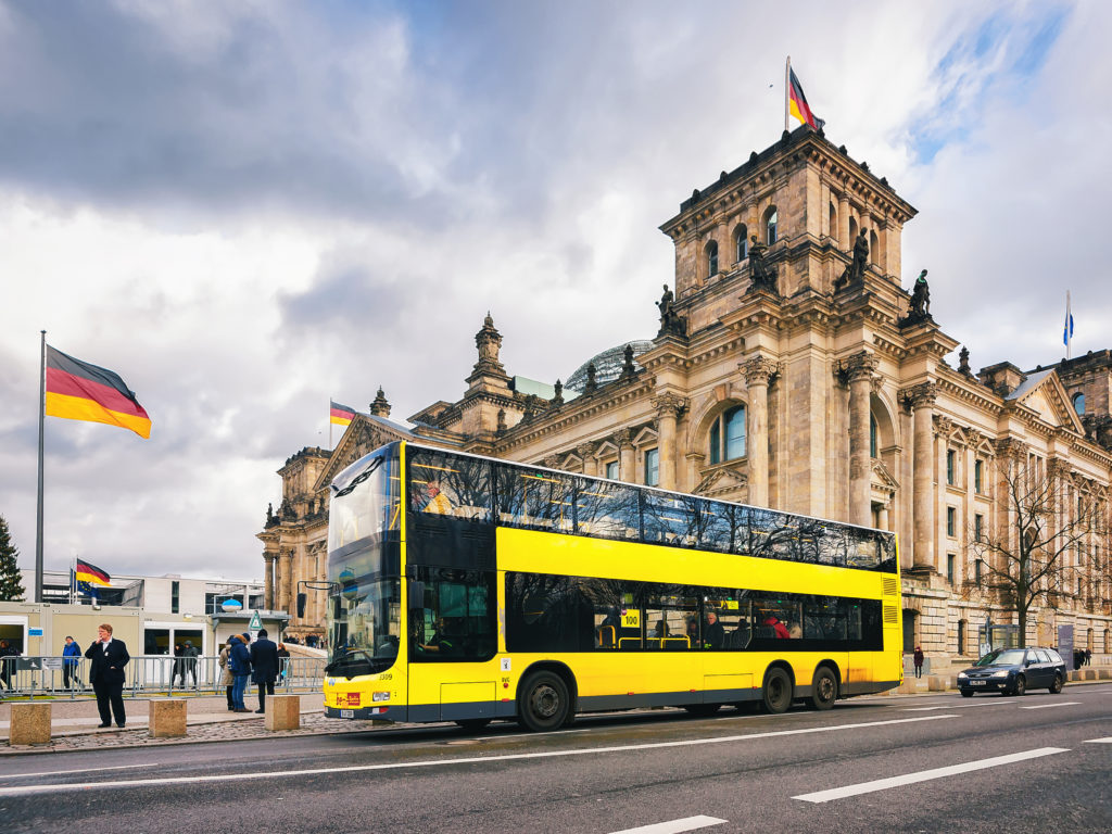 Gele toeristische bus bij het Reichstag gebouw in Berlijn, Duitsland