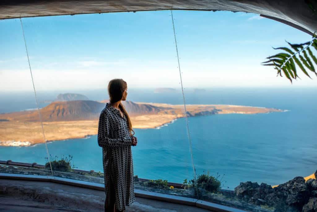 Toerist kijkt uit het raam naar Graciosa bij Mirador del Río op Lanzarote