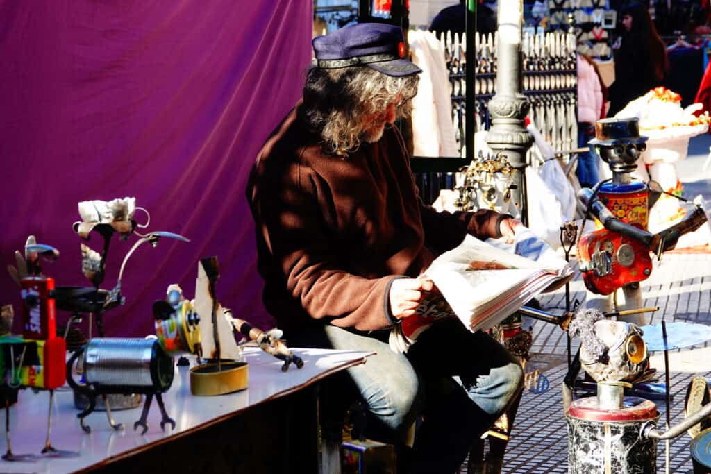 Man leest krant op de El Rastro markt in Madrid, Spanje