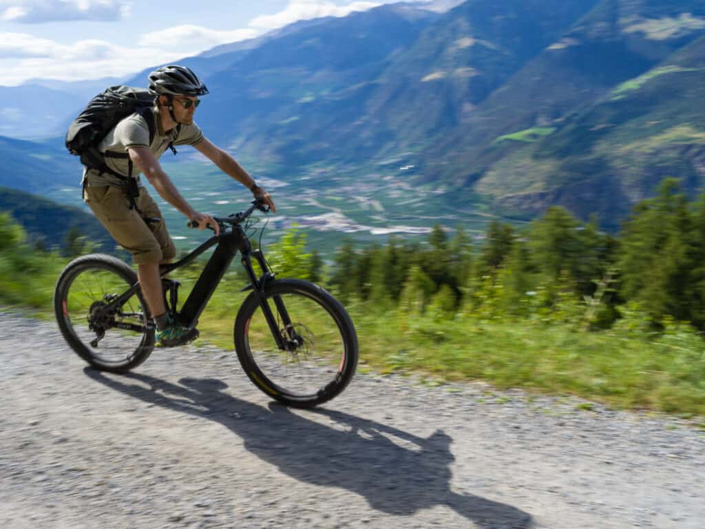 Man fietst op een elektrische mountainbike door de Alpen