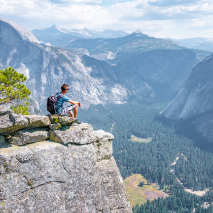 Man zit op de rand van de klif met uitzicht op El Capitan in Yosemite National Park