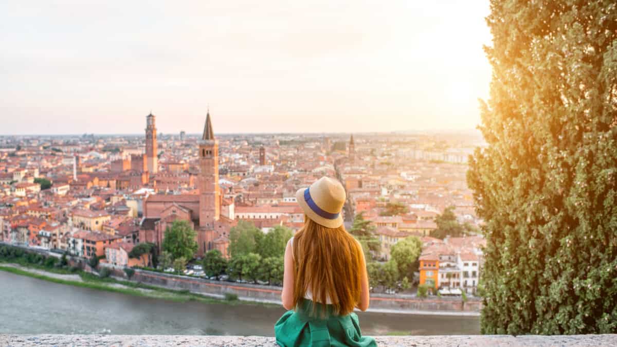 Jonge vrouw kijkt uit over de stad Verona in Italië