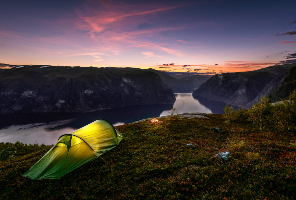 Verlichte tent in de avond met uitzicht op de Aurlandsfjord in Noorwegen