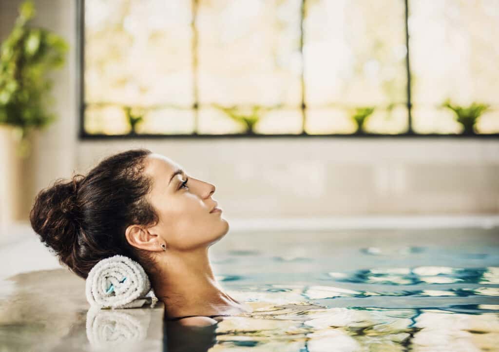 Vrouw ligt ontspannen in een zwembad van een wellness center
