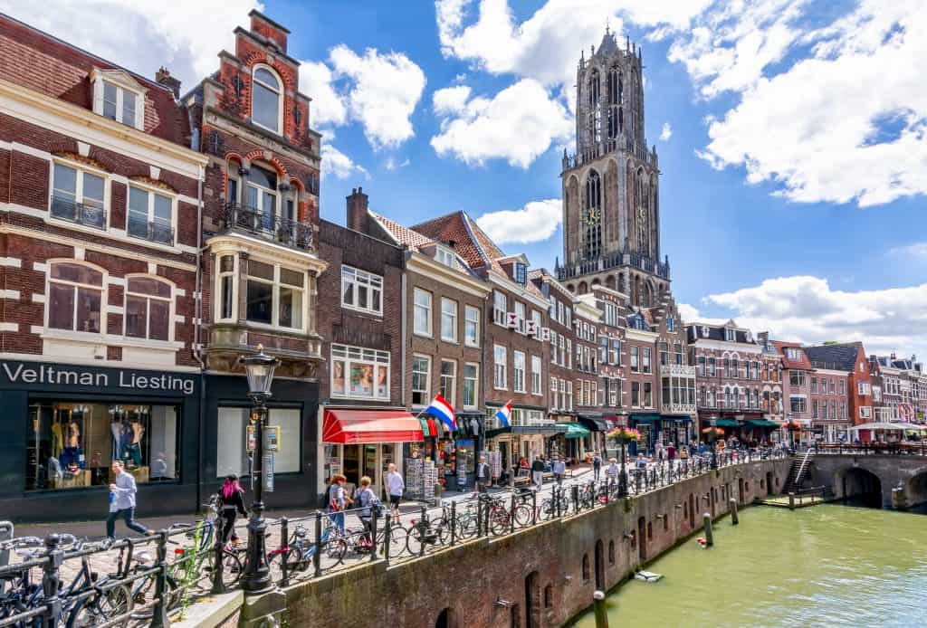 Winkelstraat langs de grachten en uitzicht op de Domtoren in Utrecht