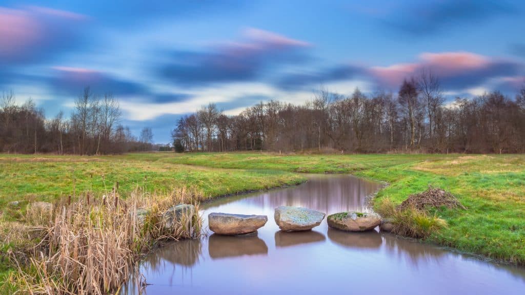 Hunebed stenen over een kleine rivier in Drenthe