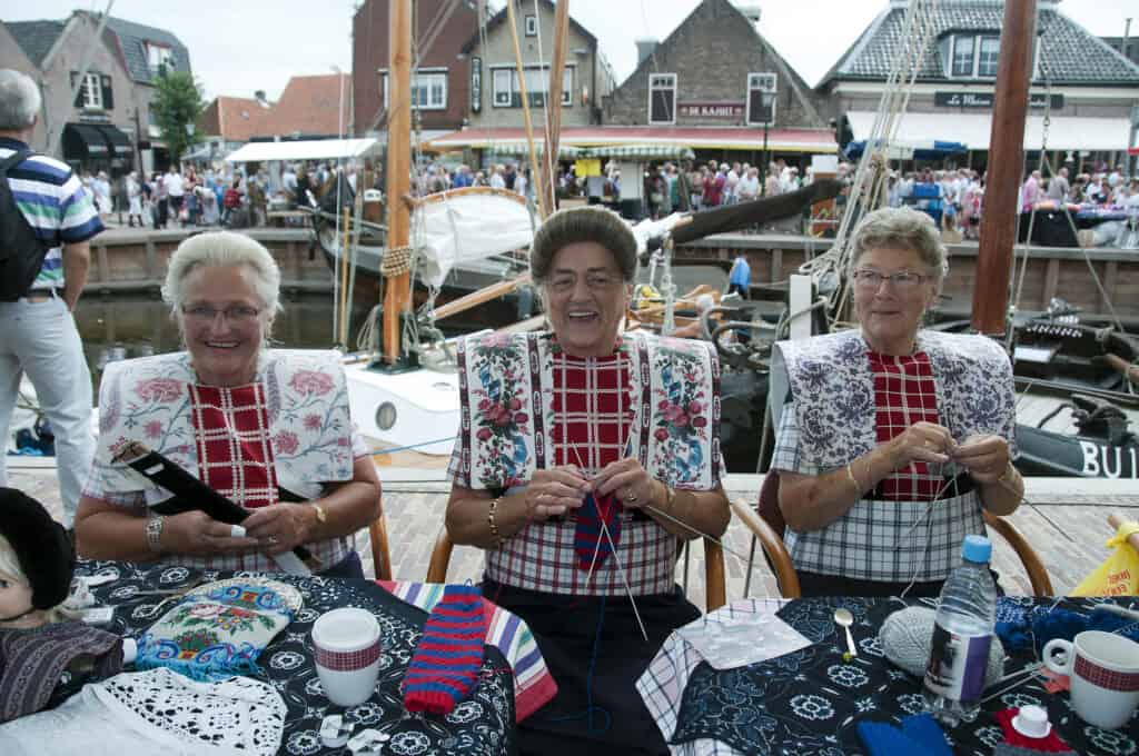Drie vrouwen in traditionele klederdracht in Spakenburg, Gelderland