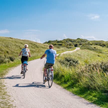 Twee mensen fietsen op Het Oerd op het waddeneiland Ameland, Nederland