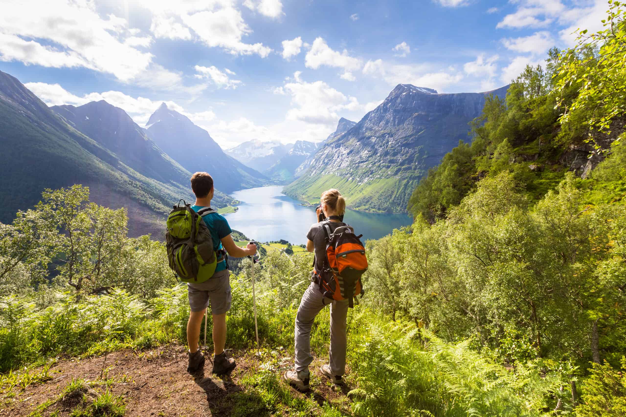 Twee hikers kijken uit bovenop een berg over een meer en berglandschap