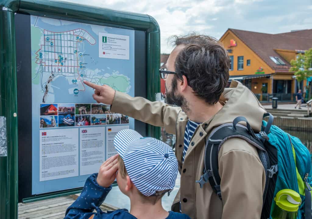 Toeristen kijken naar een plattegrond van Kristiansand in Noorwegen