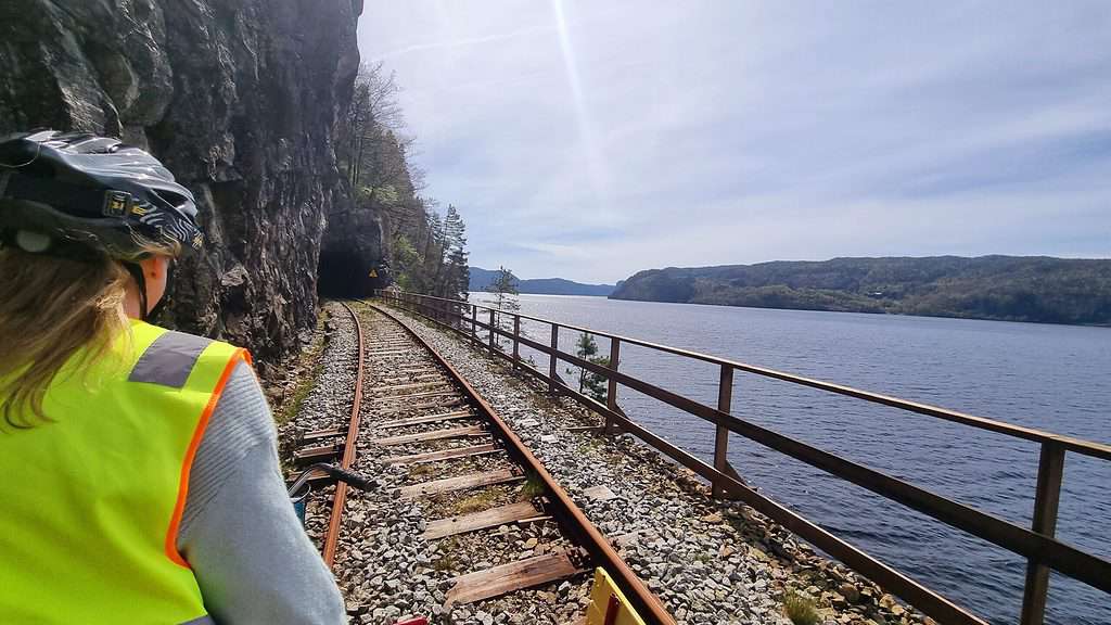 Op de fiets van de Flekkefjordbanen langs een meer en richting een tunnel